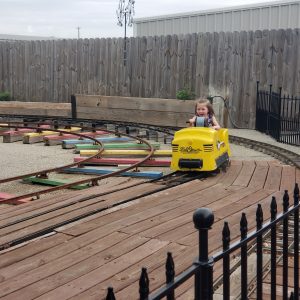 Little girl riding hand crank train