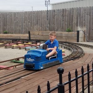 Little boy riding hand crank train