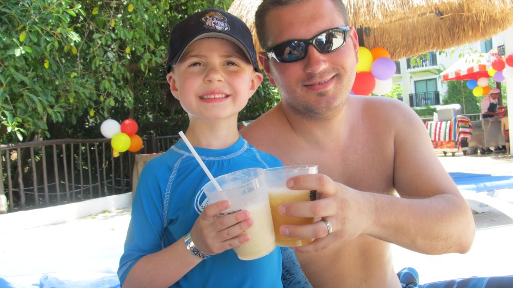 Boy drinking smoothie with dad