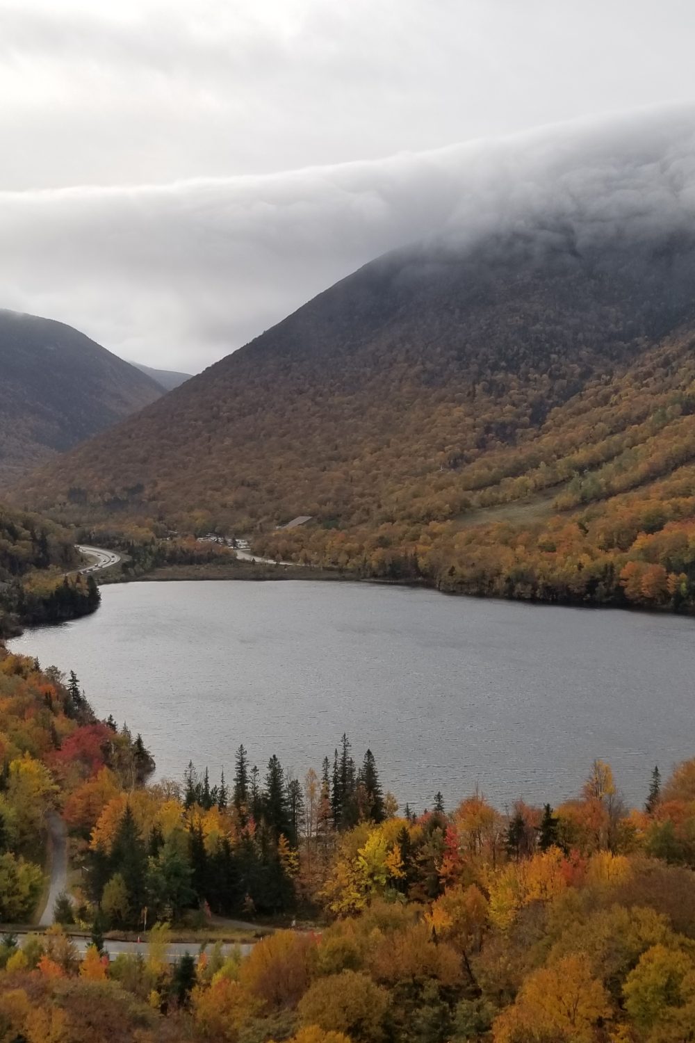 The beautiful view from Artist's Bluff in Fanconia Notch State Park in New Hampshire.  The lake surrounded by the fall changing leaves is stunning.
