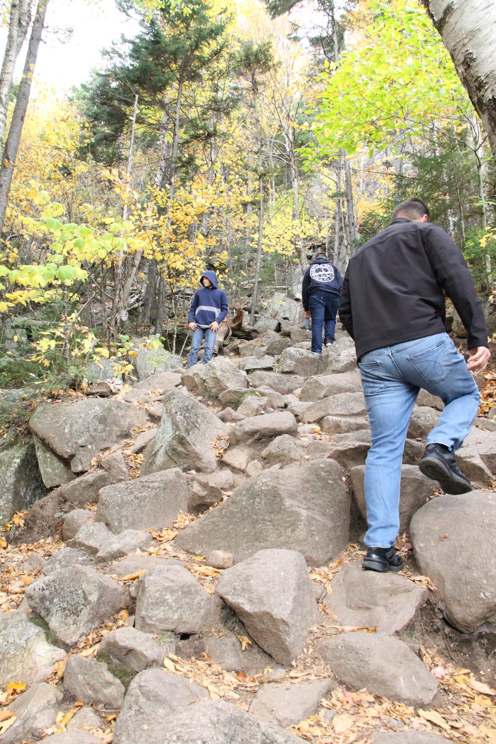 Hiking the trail, climing big boulders, to Artist's Bluff in Franconia Notch State Park.