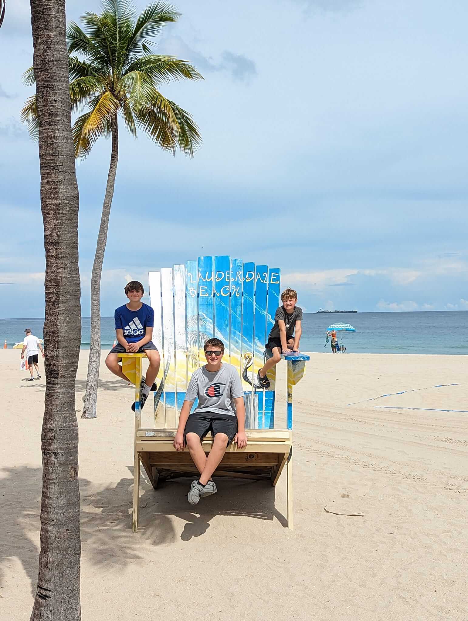 Boys sitting in a large beach chair on Fort Lauderdale Beach