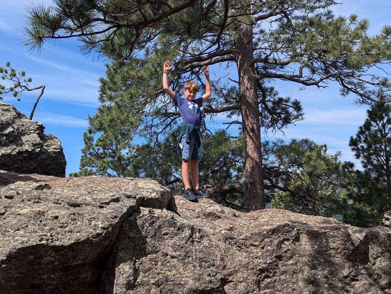 Tyler climing rocks on a stop on Iron Mountain Road