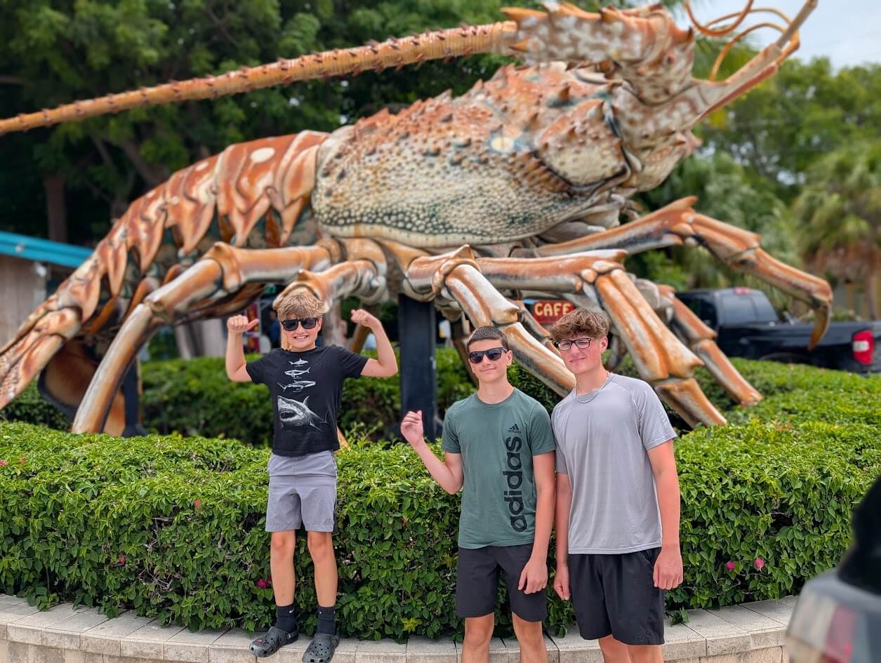 Our kids posing with Betsy, the giant lobster at Rain Barrel Village