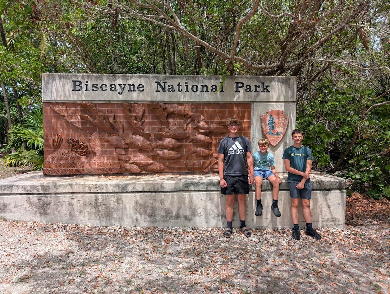 Our 3 kids in front of the Biscayne National Park sign