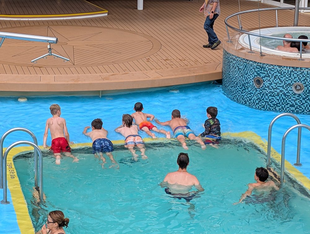 Boys at the pool with new friends on the cruise ship